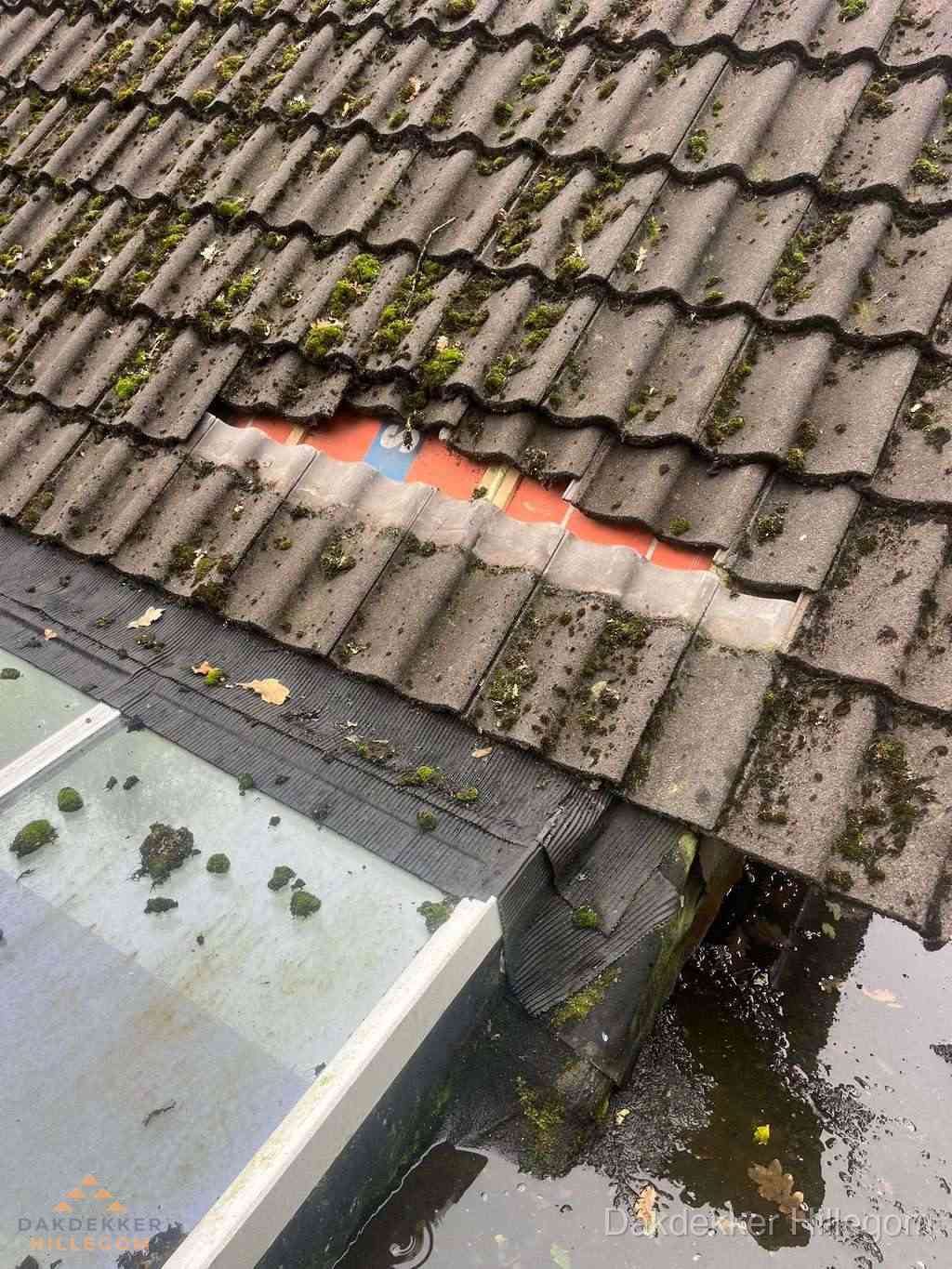 Beschadigd pannendak met ontbrekende dakpannen voor reparatie in Hillegom