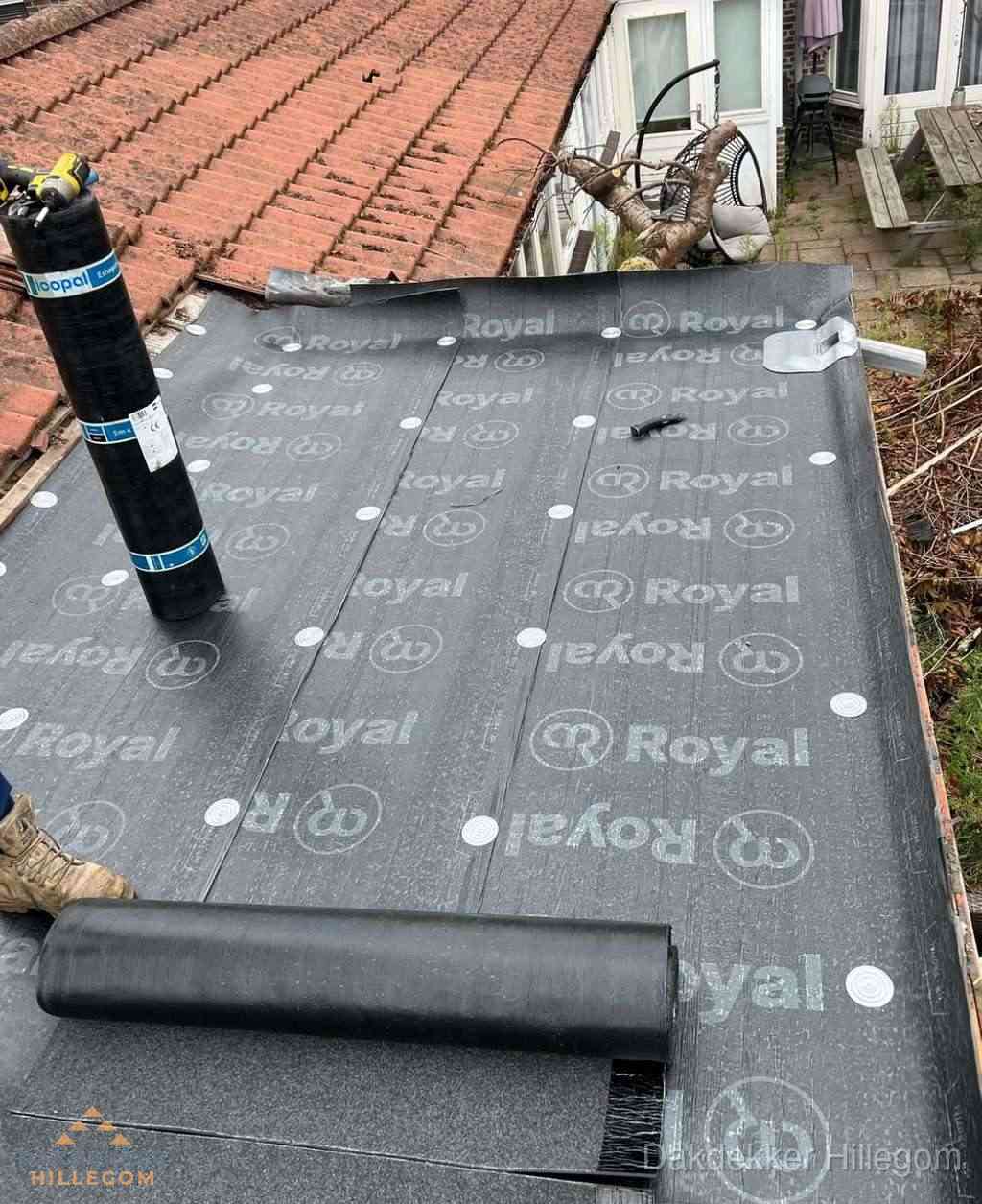 Plat dak met nieuwe bitumen dakbedekking en brandgereedschap in Hillegom