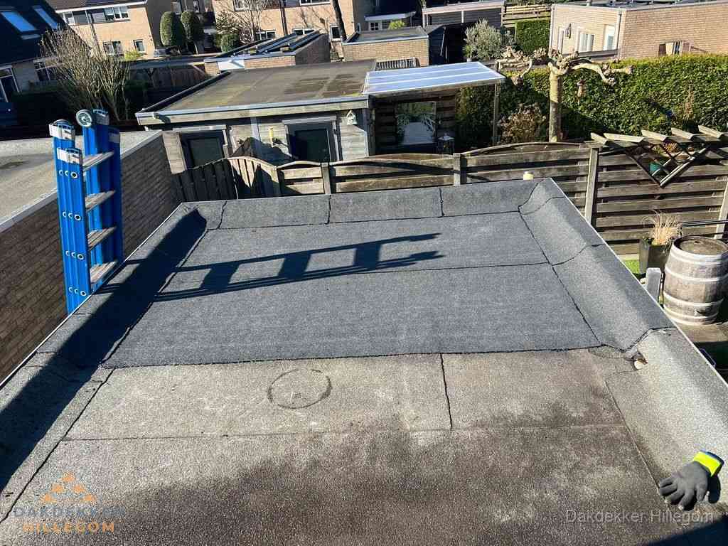 Dakdekker legt onderlaag op plat dak met houten constructie in Hillegom