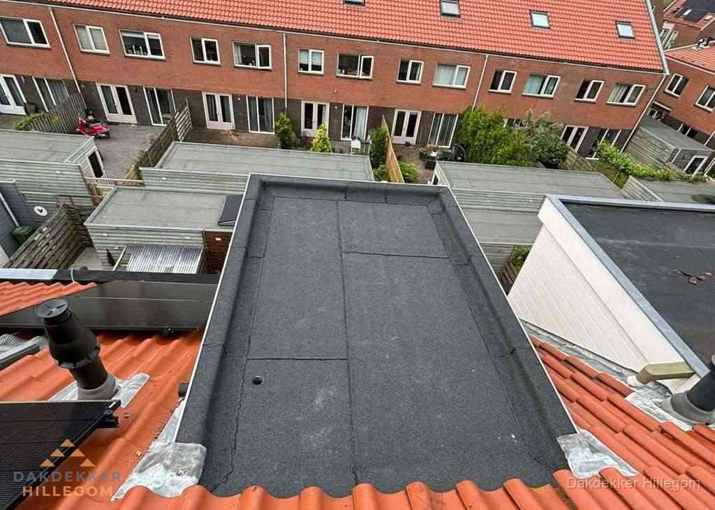 Plat dak met bitumen bedekking naast dakkapel in Hillegom