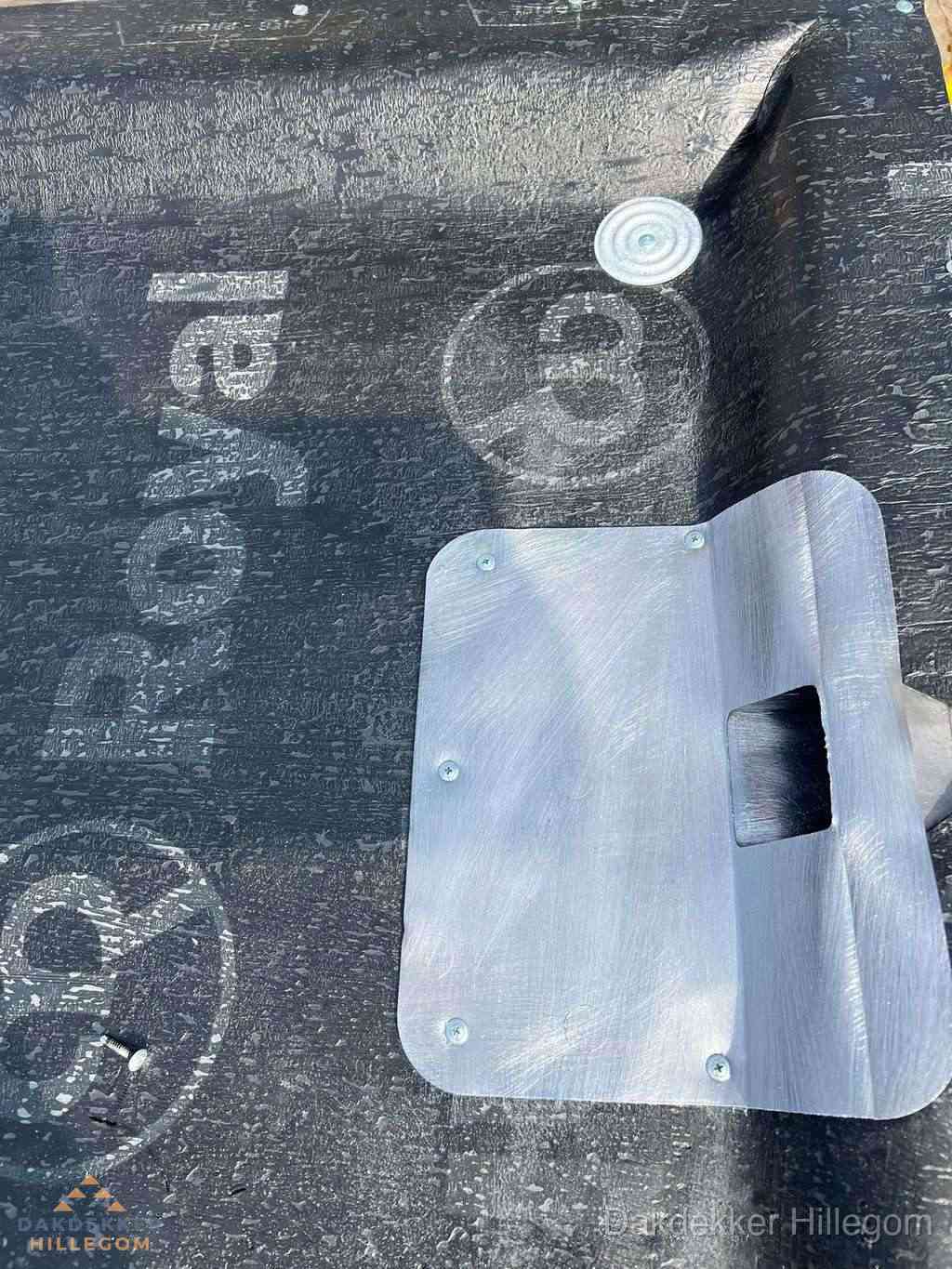 Dakdoorvoer met metalen afvoerplaat op bitumen dak in Hillegom