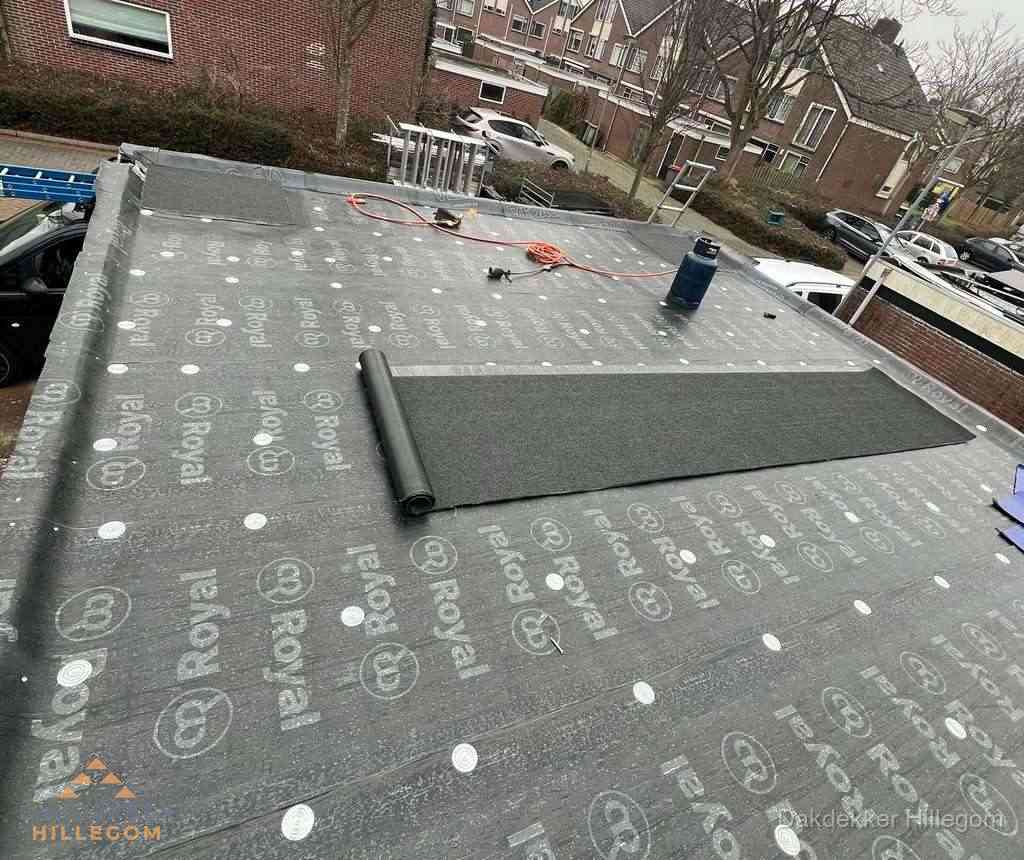 Dakdekker aan het werk met gasbrander op plat bitumen dak in Hillegom