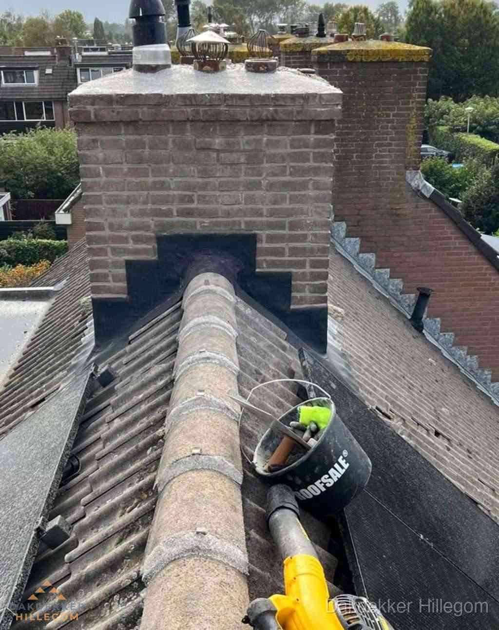 Dakdekker repareert bitumen dakleer bij dakdoorvoer in Hillegom